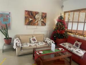 una sala de estar con un árbol de Navidad y un sofá en Hotel Palermo Quintero en Quintero