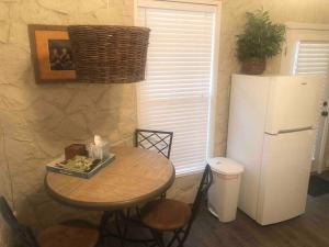 uma cozinha com uma mesa e um frigorífico em Bunkhouse at the Silver Spur Dancehall Ruins~Bandera, TX. em Bandera