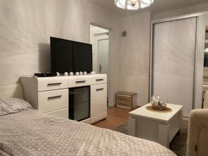 a bedroom with a bed and a flat screen tv at White home apartment in Banja Luka