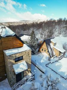 a house covered in snow with snow covered roofs at Kežman Mountain Houses in Kopaonik