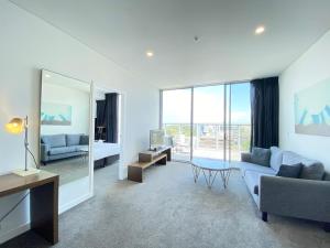 uma sala de estar com um sofá e uma mesa em Premium Apartments Chatswood em Sidney