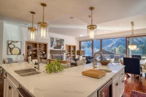 a kitchen with a sink and a living room at Luxe Ketchum Penthouse with Rooftop Hot Tub in Ketchum