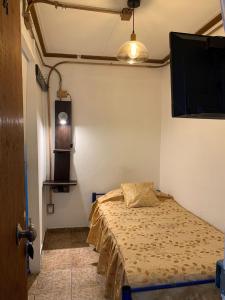 um quarto com uma cama e uma televisão de ecrã plano em Residencial La Piramide em Iquique