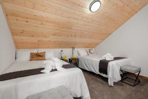- 2 lits dans une chambre dotée de plafonds en bois dans l'établissement Cozy Pines, à Ashford
