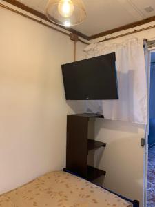 uma televisão de ecrã plano numa bancada num quarto em Residencial La Piramide em Iquique