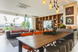 Una cocina y una sala de estar con una mesa y sillas de madera. en Condominio Quay Luxury, en Florianópolis