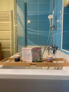 a bathroom sink with two candles and books on it at Appartement proche centre/gare in Le Mans +11 photos