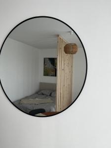 een spiegel aan de muur met een bed in een kamer bij Le chic appartement de Gagny/parking gratuit in Gagny