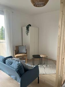 een woonkamer met een bank en een stoel bij Le chic appartement de Gagny/parking gratuit in Gagny