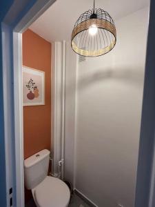 een badkamer met een toilet en een kroonluchter bij Le chic appartement de Gagny/parking gratuit in Gagny