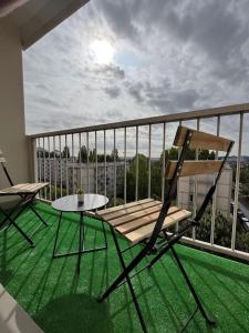 een balkon met 2 stoelen en een tafel bij Le chic appartement de Gagny/parking gratuit in Gagny