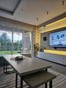 a living room with a table and a tv at Villa Aida in Sarajevo