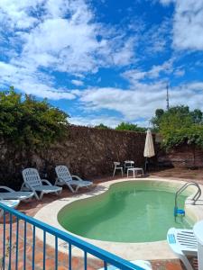 a swimming pool with chairs and a table at La Casona de Moldes in Coronel Moldes