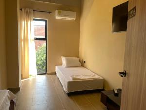 - une petite chambre avec un lit et une fenêtre dans l'établissement Awa House Hotel, à Aguachica