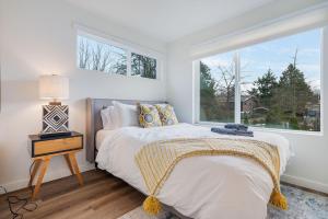 een witte slaapkamer met een bed en een raam bij Ballard Market St Haven BY Betterstay in Seattle