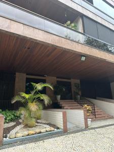 Vila de Ofir recreio dos Bandeirantes 200m da Praia في ريو دي جانيرو: مبنى امامه درج والنخيل