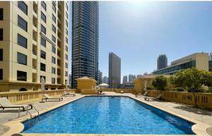 a large swimming pool in a city with tall buildings at Usmans 4BDRM APARTMENT SEA VIEW Rimal in Dubai