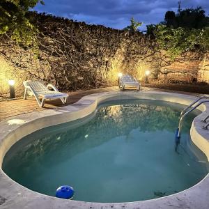a small swimming pool with two chairs and a table at La Casona de Moldes in Coronel Moldes