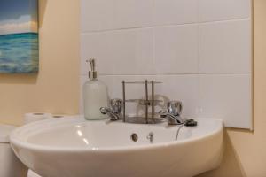 a white bathroom sink with a soap bottle on it at property discarded in London