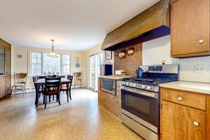 a kitchen with a stove and a dining room at Sugarwood Farmhouse in Wilmington