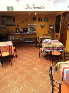 a restaurant with tables and chairs and a kitchen at Hotel Doña Alicia in Oaxaca City