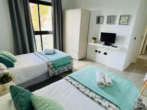 San AndrésにあるTeresitas Sea Viewsのベッド2台とテレビがあるホテルの部屋