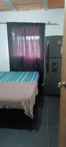 een kamer met een koelkast en een bed erin bij Edificio Lozano 2H in Cali