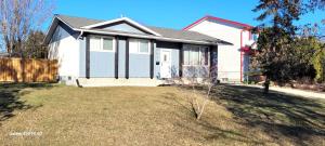 een wit en zwart huis met een tuin bij Home away from home - 6 bedroom fantastic bungalow in Winnipeg