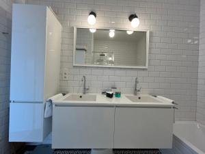 Baño blanco con 2 lavabos y espejo en Luxury apartment, private terrace & FREE PARKING, en Amberes