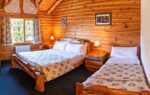 a bedroom with two beds in a log cabin at Hostería Epulén in Villa La Angostura