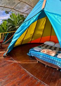 a bed in a tent on a deck at Mano del Gigante Nomada in Gigante