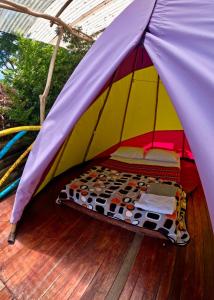 a bed in a tent on a deck at Mano del Gigante Nomada in Gigante