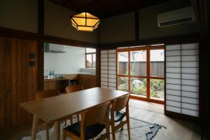 a dining room with a wooden table and chairs at willow. in Toyooka