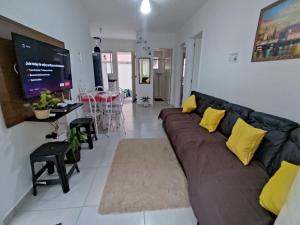 - un salon avec un canapé et une salle à manger dans l'établissement Cond Cristal Indaiá I Ap23, WI-FI, 450m praia Indaiá, check-out 16h, à Bertioga
