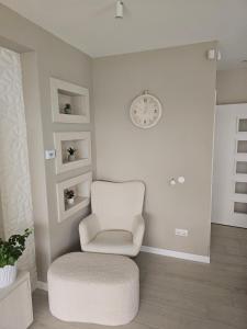 a white living room with a chair and a clock at Villa Aida in Sarajevo