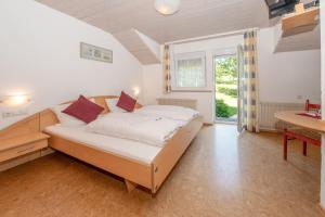 Schlafzimmer mit einem Bett, einem Schreibtisch und einem Fenster in der Unterkunft Landgasthof Adler in Amtzell