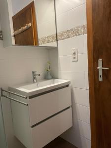 a white bathroom with a sink and a mirror at Bellevue A; nr. 301. in La Tzoumaz