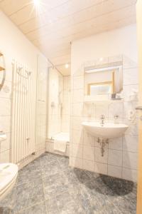Landgasthof Adler في Amtzell: حمام أبيض مع حوض ومرحاض