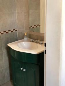 a bathroom with a sink and a green cabinet at El Aura in Colón