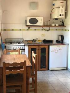 a kitchen with a table and a stove and a refrigerator at El Aura in Colón