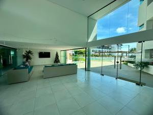 een grote woonkamer met een grote glazen wand bij Flat Luxo - Pé na Areia - Maui Beach Residence in Tamandaré
