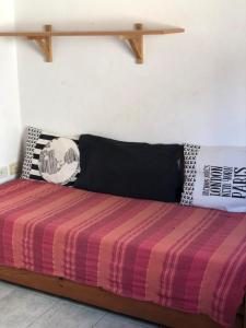 Bett mit gestreifter Decke in einem Zimmer in der Unterkunft El Aura in Colón