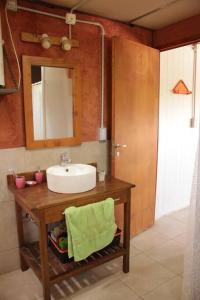 un baño con lavabo y espejo en Cabaña El Bosquecito con vista al dique, en Potrerillos