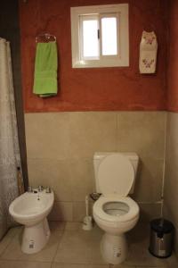 ポトレリージョスにあるCabaña El Bosquecito con vista al diqueのバスルーム(トイレ、洗面台付)、窓が備わります。