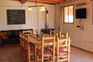 Un comedor con mesa y sillas de madera. en Cabaña El Bosquecito con vista al dique, en Potrerillos