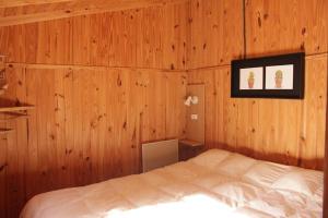 ポトレリージョスにあるCabaña El Bosquecito con vista al diqueの木製の壁のベッドルーム1室