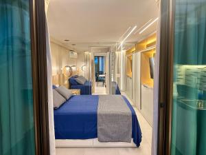 een slaapkamer met een blauw bed in een kamer bij Flat Luxo - Pé na Areia - Maui Beach Residence in Tamandaré +110 foto's