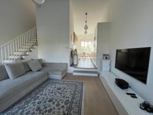 sala de estar con sofá y TV de pantalla plana en Luxury apartment, private terrace & FREE PARKING, en Amberes