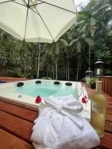 a bath tub with a towel and a bottle of wine at Jardins da Vila - Farm house in Blumenau