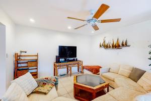 a living room with a couch and a ceiling fan at Aqua Parrot in Largo